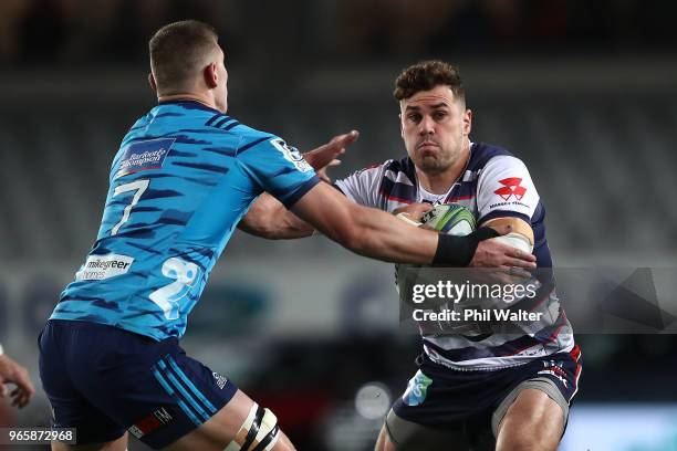 Tom English of the Rebels is tackled by Dalton Papalii of the Blues during the round 16 Super Rugby match between the Blues and the Rebels at Eden...