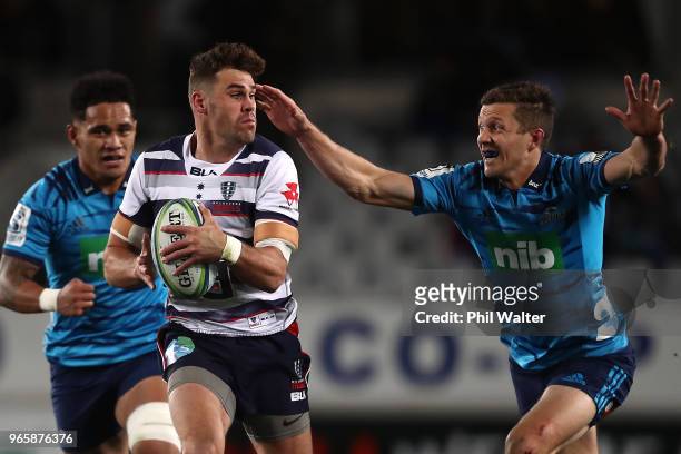 Tom English of the Rebels escapes the tackled of Matt Duffie of the Blues during the round 16 Super Rugby match between the Blues and the Rebels at...