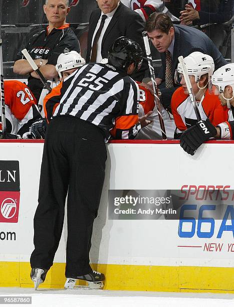 Head Coach Peter Laviolette of the Philadelphia Flyers has a discussion with referee Marc Joannette during a timeout against the New Jersey Devils...