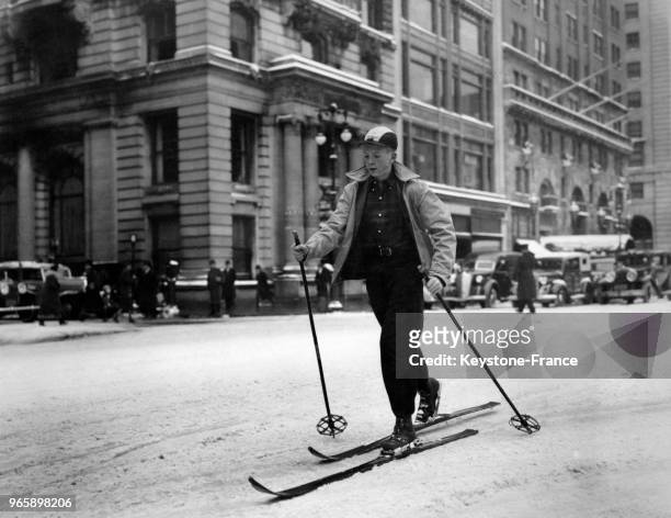 Homme en ski de fond dans les rues enneigées à New York City, Etats-Unis le 14 janvier 1939.