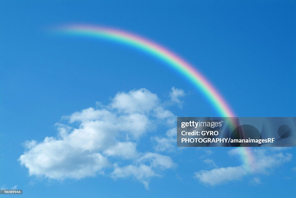 Clouds and rainbow in blue sky, computer graphic