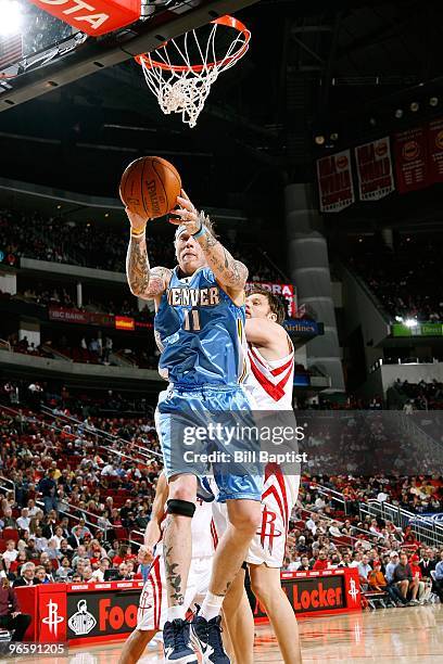 Chris Andersen of the Denver Nuggets rebounds the ball against David Andersen of the Houston Rockets during the game on January 27, 2010 at the...