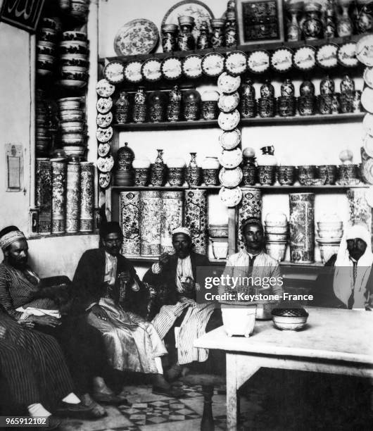 Des hommes assis sur les sofas d'un café fument le narguilé le 13 août 1931 à Damas, Syrie.