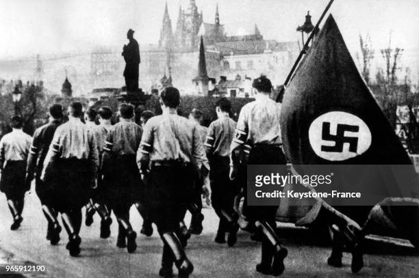 Défilé d'étudiants nazis sur le pont Charles venus accueillir Hitler, à Prague, Tchécoslovaquie le 15 mars 1939.