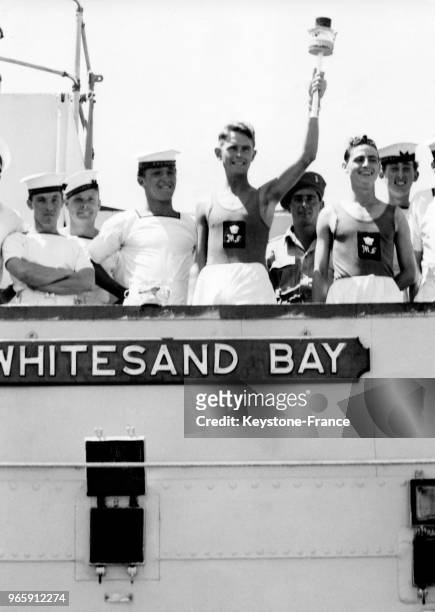 Arrivée de la flamme olympique sur le bateau Whitesand Bay escortée par des marins le 19 juillet 1948 à Bari, Italie.