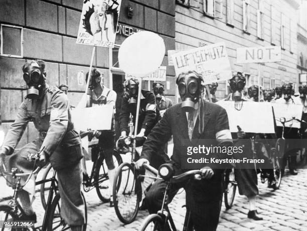 Des sauveteurs avec masques à gaz parcourent à bicyclette les rues de la ville, portant des pancartes pour avertir la population des dangers de la...