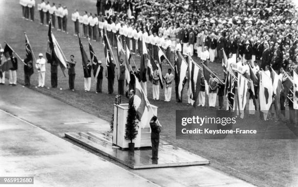 Les représentants des équipes des différentes nations dont les drapeaux sont présents tout autour du stade prêtent serment à la tribune lors des Jeux...