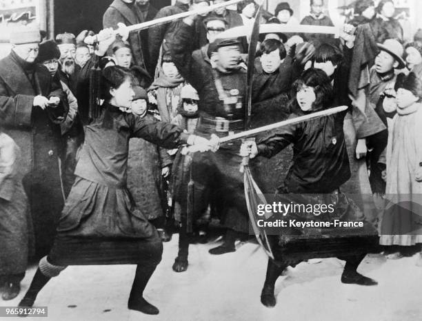 Deux femmes disputent un combat d'escrime dans les rues le 18 janvier 1935 à Pékin, Chine.