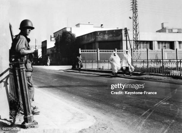 Un soldat surveille la rue où ont été érigées des barricades après de violentes attaques le 22 août 1955 à Casablanca, Maroc.