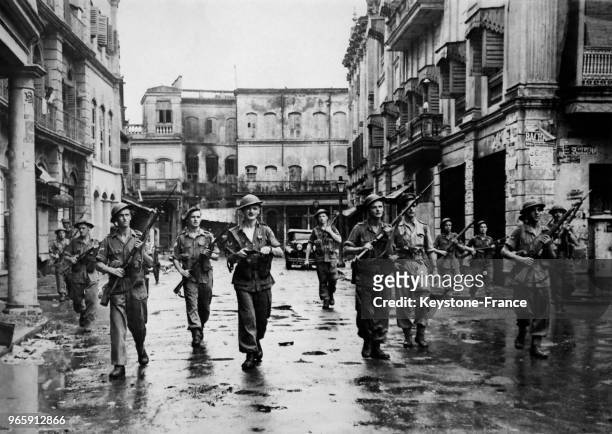 Les militaires britanniques, armes au poing, patrouillent pour le maintien de l'ordre dans les rues désertes de la ville, après les émeutes qui ont...