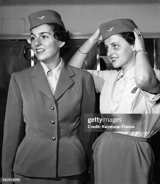 Les hôtesses de l'air de la German Air Traffic Corporation présentant leurs nouveaux uniformes créés par Binder-Verle: un tailleur jupe bleu foncé...
