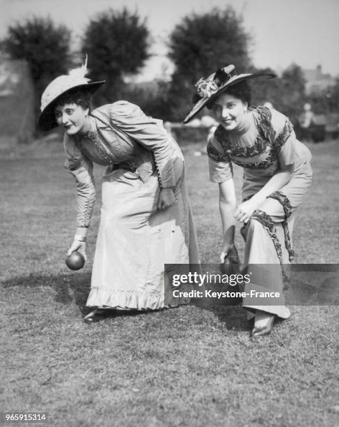 Deux jeunes femmes jouent aux boules lors d'une fête florale le 25 août 1934 à Oxford, Royaume-Uni.