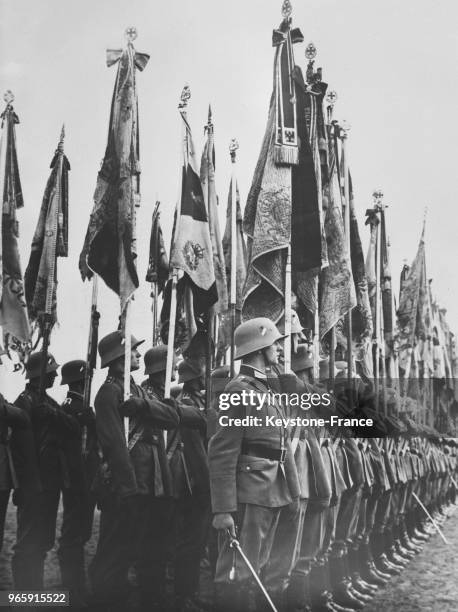 Les drapeaux de la Guerre, ornés de leurs décorations défilent, à Berlin, Allemagne le 18 mars 1935.