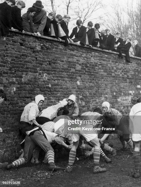 Des écoliers assis sur un mur assistent au traditionnel St Andrews Day Wall Game le 30 novembre 1959 à Eton, Royaume-Uni.