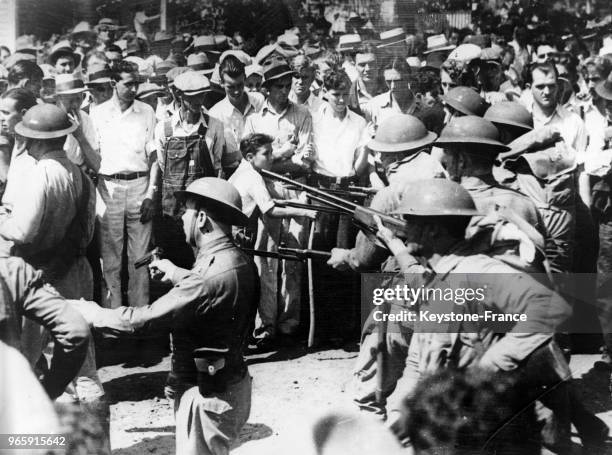 Des gardes nationaux, baïonettes au canon, mantiennent les grévistes du textile à Greenville, Caroline du Sud, Etats-Unis le 15 septembre 1934.