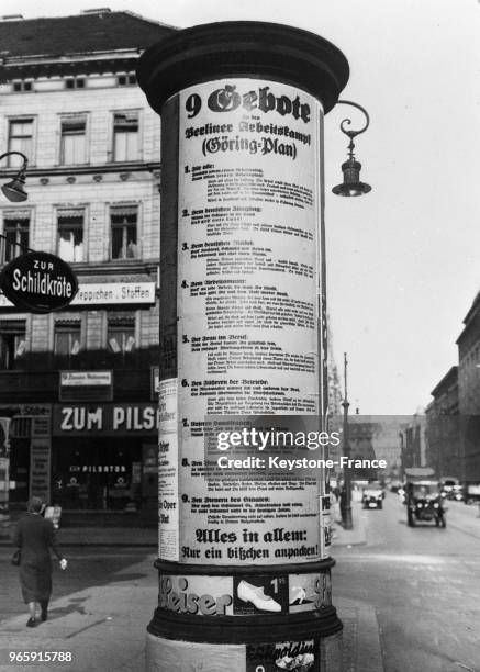 Les 'neuf commandements' du dignitaire nazi Hermann Göring affichés sur une colonne publicitaire dans la rue le 26 mai 1934 à Berlin, Allemagne.