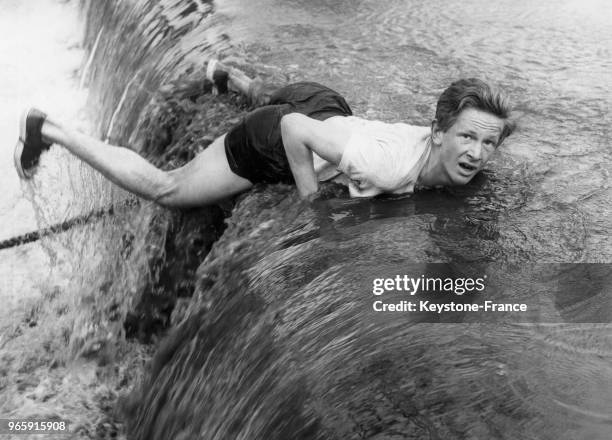 Un étudiant anglais trébuche sur un tuyau recouvert d'eau en cascade lors de la course annuelle d'obstacle de l'université Bradfield College le 31...