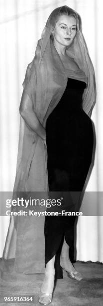 Mannequin présentant un modèle Sheelagh Lynch de la Collection Automne 1956: une robe en crèpe noire et organza turquoise, portée avec une étole, à...