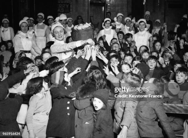Distribution de cadeaux pour les enfants par les infirmières de Barts Hospital, à Londres, Royaume-Uni le 26 décembre 1933.
