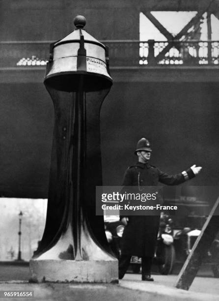 Un agent de circulation près d'un 'phare' de signalisation routière à Charing Cross le 16 décembre 1932 à Londres, Royaume-Uni.