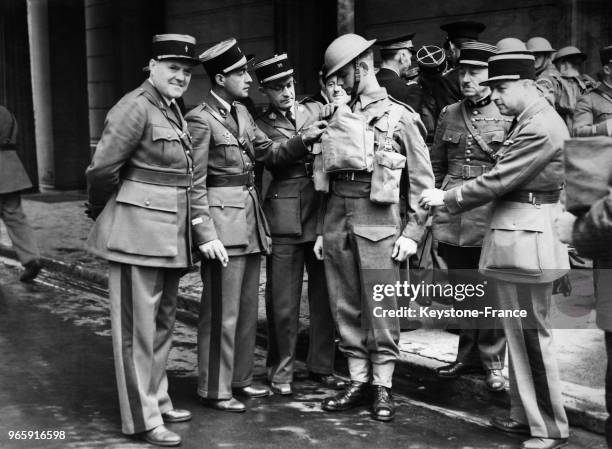 Des officiers français examinent l'uniforme d'un soldat anglais à la caserne de Wellington, à Londres, Royaume-Uni le 16 mai 1939.