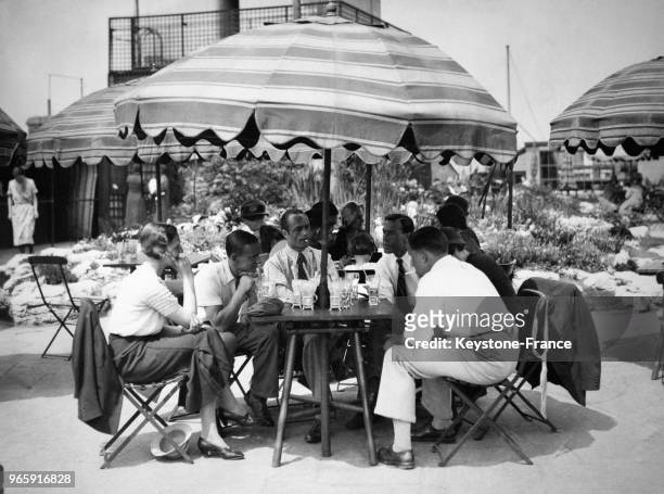 Des travailleurs en costume ont tombé la veste lors d'un déjeuner sur la terrasse d'un immeuble du West End le 23 mai 1933 à Londres, Royaume-Uni.