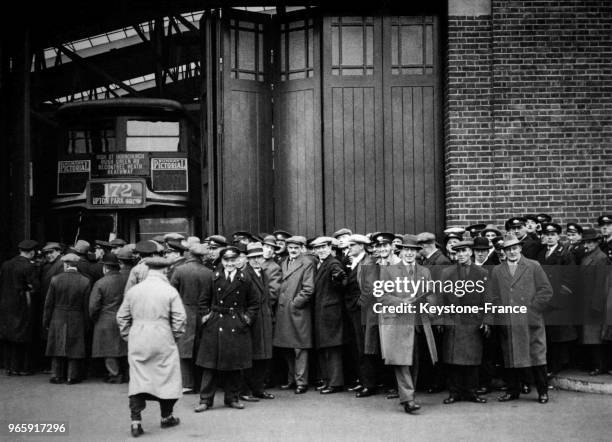 Travailleurs faisant la queue devant Upton Park Garage pour recevoir le paie, à Londres, Royaume-Uni le 20 janvier 1933.