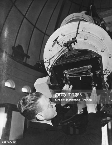 Astronome plaçant un cache sur la lunette astronimique à monture équatoriale de l'observatoire de Greenwich à Londres, Royaume-Uni le 24 mai 1946.