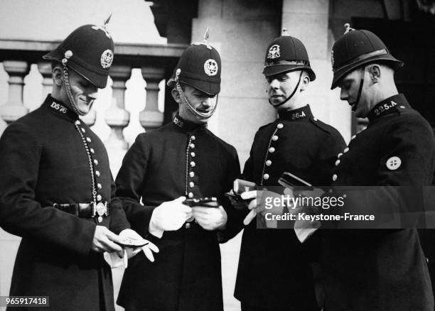 Quatre policiers à la sortie de Buckingham après avoir été décorés de la médaille du courage, à Londres, Royaume-Uni le 17 février 1934.