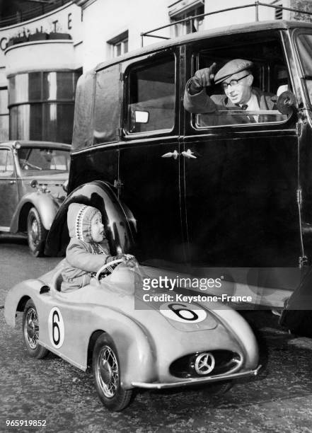 Un petit garçon américain au volant d'une voiture miniature demande son chemin à un chauffeur de taxi anglais afin de se rendre à la foire du jouet,...