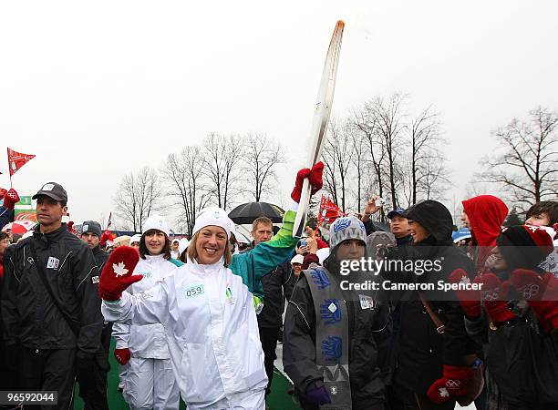 Kristi Blakeway carries the Olympic Flame during the Vancouver 2010 Olympic Torch Relay ahead of the Vancouver 2010 Winter Olympics on February 11,...