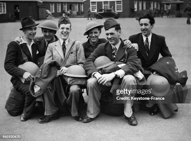 Groupe de jeunes recrues heureux après avoir reçu uniforme et casque, à Londres, Royaume-Uni le 15 septembre 1939.