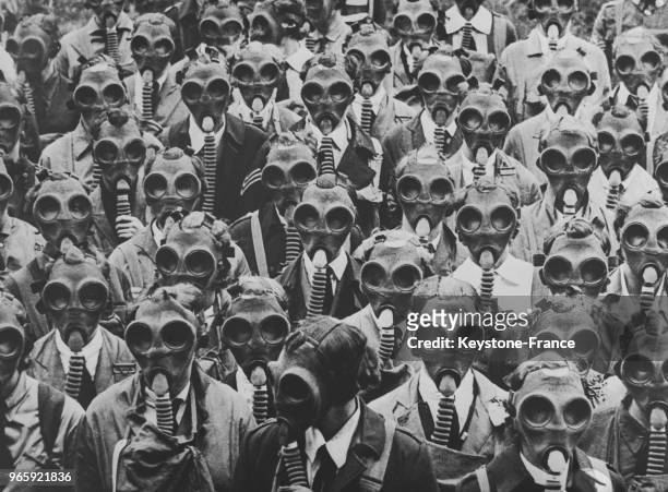 Un groupe d'infirmiers munis de masques à gaz photographié pendant un exercice de défense passive à Londres, Royaume-Uni le 22 mai 1935.