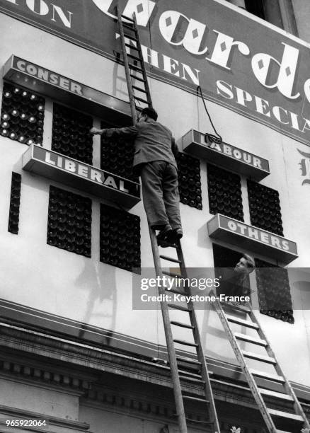 Un ouvrier installe l'écran géant sur Piccadilly Circus qui donnera le résultat des élections, à Londres, Royaume-Uni le 25 ocotbre 1951.