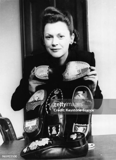 Miss Joan Verney observe plusieurs exemplaires de chaussures en cuir décorées dans le cadre d'un concours le 31 janvier 1949 à Londres, Royaume-Uni.