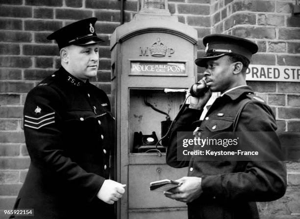 Un policier reçoit sur le téléphone d'urgence un message de la centrale, à Londres, Royaume-Uni le 17 mars 1950.