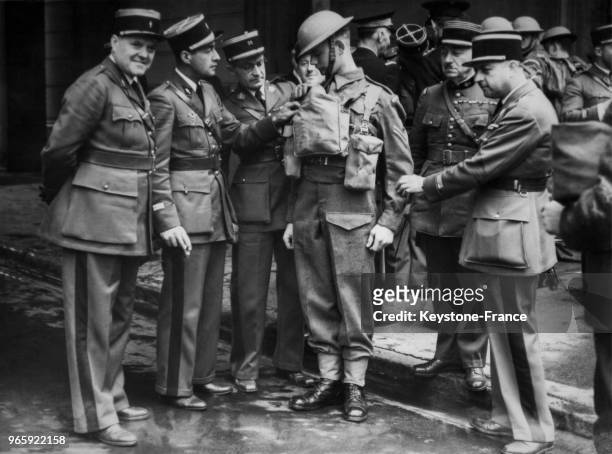 Des officiers français examinent le nouvel uniforme d'un soldat britannique lors de leur visite dans la caserne de Wellington, à Londres, Royaume-Uni...