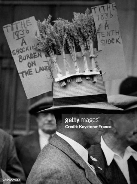 Un manifestant coiffé d'un chapeau orné d'épis de maïs dans le cortège des paysans à Londres, Royaume-Uni le 24 juin 1936.