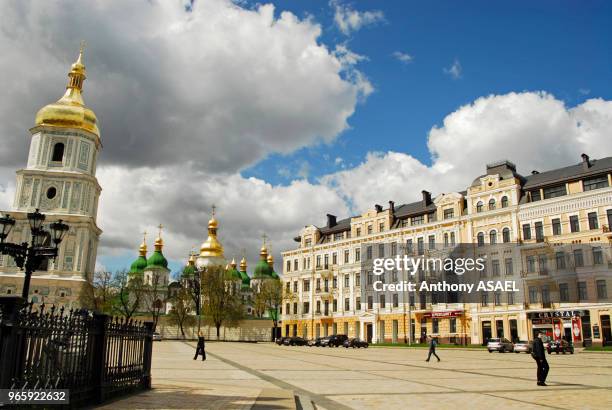 Ukraine, Kiev, Place avec une église orthodoxe blanche avec dôme vert et or, un grand bâtiment de style européen du 18ème siècle avec de nombreuses...