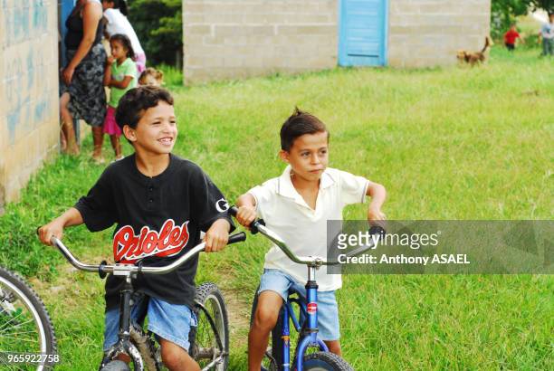 Belize, El Progreso, boy riding bicycling at school.