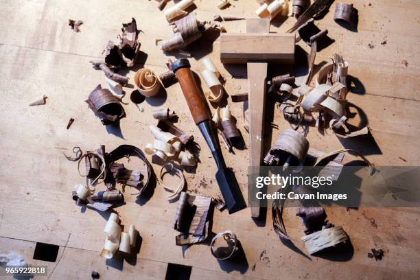 high angle view of chisel with mallet sawdust on wooden table - mallet hand tool foto e immagini stock