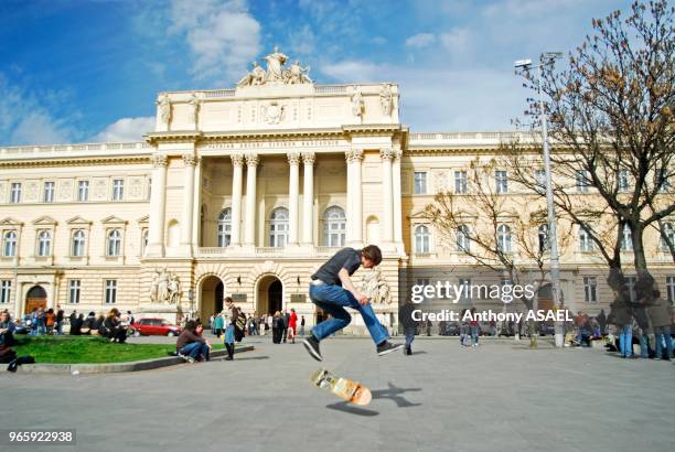 Ukraine, Lvov, adolescent faisant du skate board sur une place.