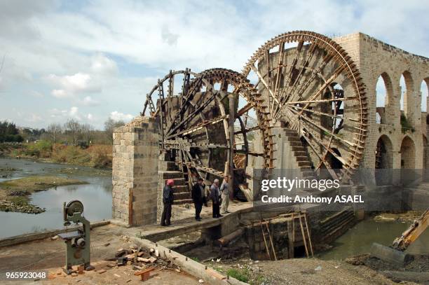 Syrian Arab Republic, Hama, wooden Norias on the Orontes River, an Arabic man sitting by an ancient wooden machine used for lifting water into an...