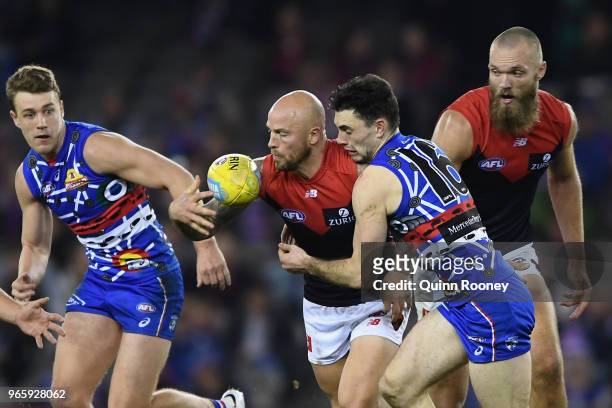 Nathan Jones of the Demons is tackled by Toby McLean of the Bulldogs during the round 11 AFL match between the Western Bulldogs and the Melbourne...