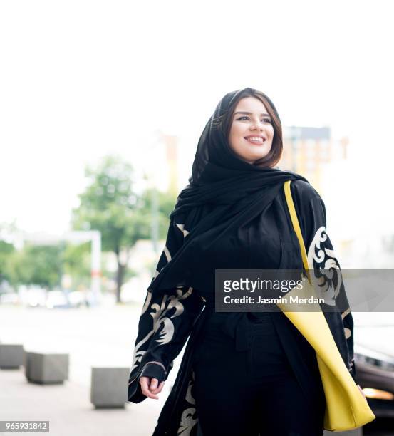 Middle Eastern young woman walking on street in city