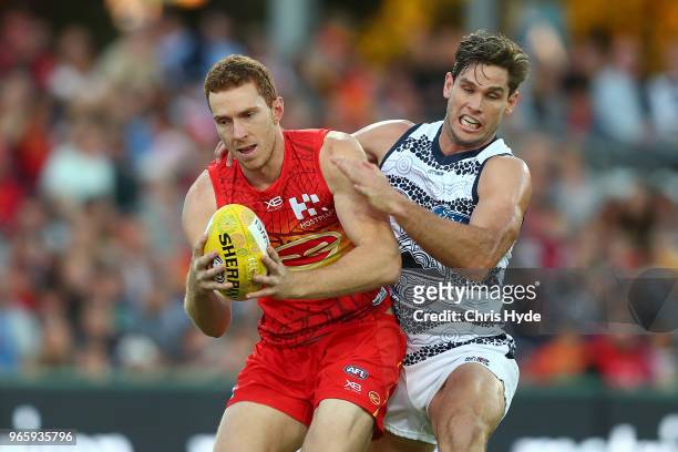 Rory Thompson of the Suns takes a mark over Tom Hawkins of the Cats during the round 11 AFL match between the Gold Coast Suns and the Geelong Cats at...