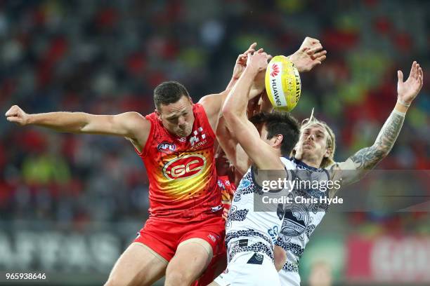 Steven May of the Suns and Tom Stewart of the Cats compete for the ball during the round 11 AFL match between the Gold Coast Suns and the Geelong...