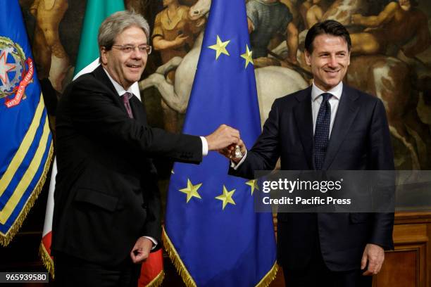 New Italian Prime Minister Giuseppe Conte receives a silver bell from former Prime Minister Paolo Gentiloni during the bell ceremony, to signify the...