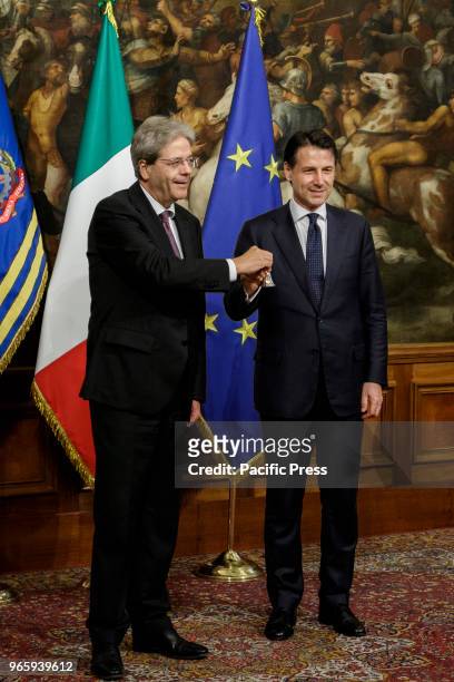 New Italian Prime Minister Giuseppe Conte receives a silver bell from former Prime Minister Paolo Gentiloni during the bell ceremony, to signify the...
