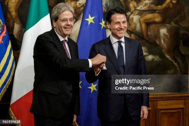 New Italian Prime Minister Giuseppe Conte receives a silver bell from former Prime Minister Paolo Gentiloni during the bell ceremony, to signify the...